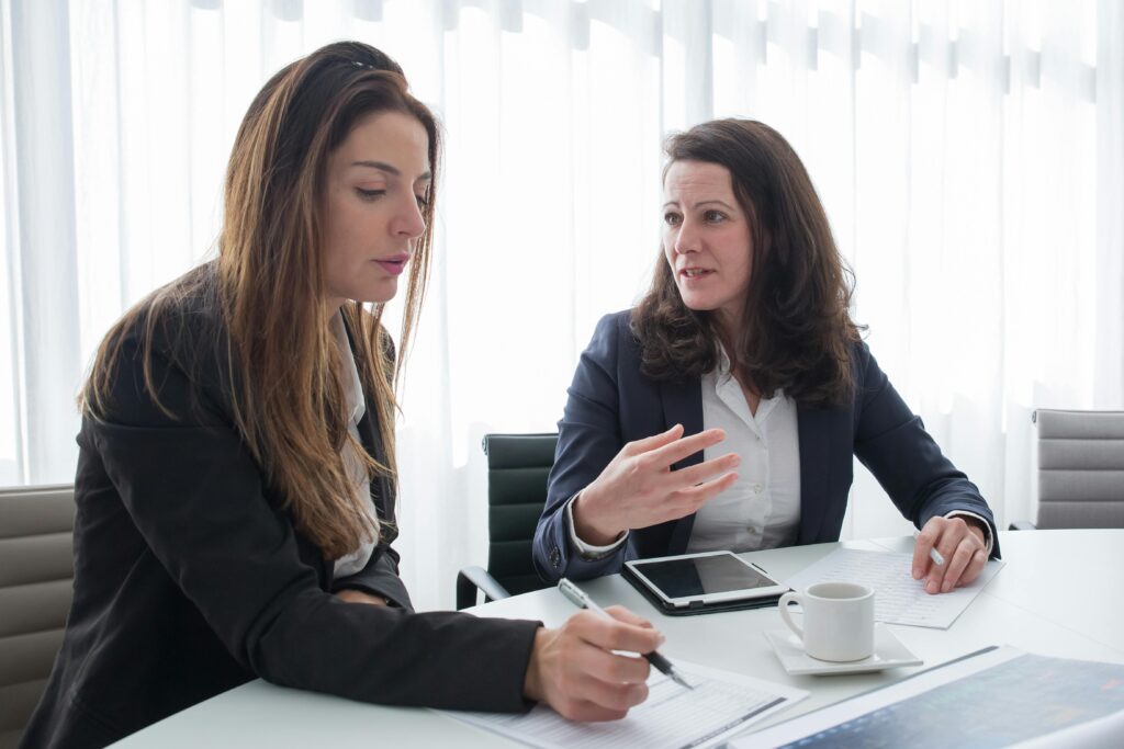 pexels photo 8171201 8171201 Two women in a business meeting discussing ideas while taking notes.